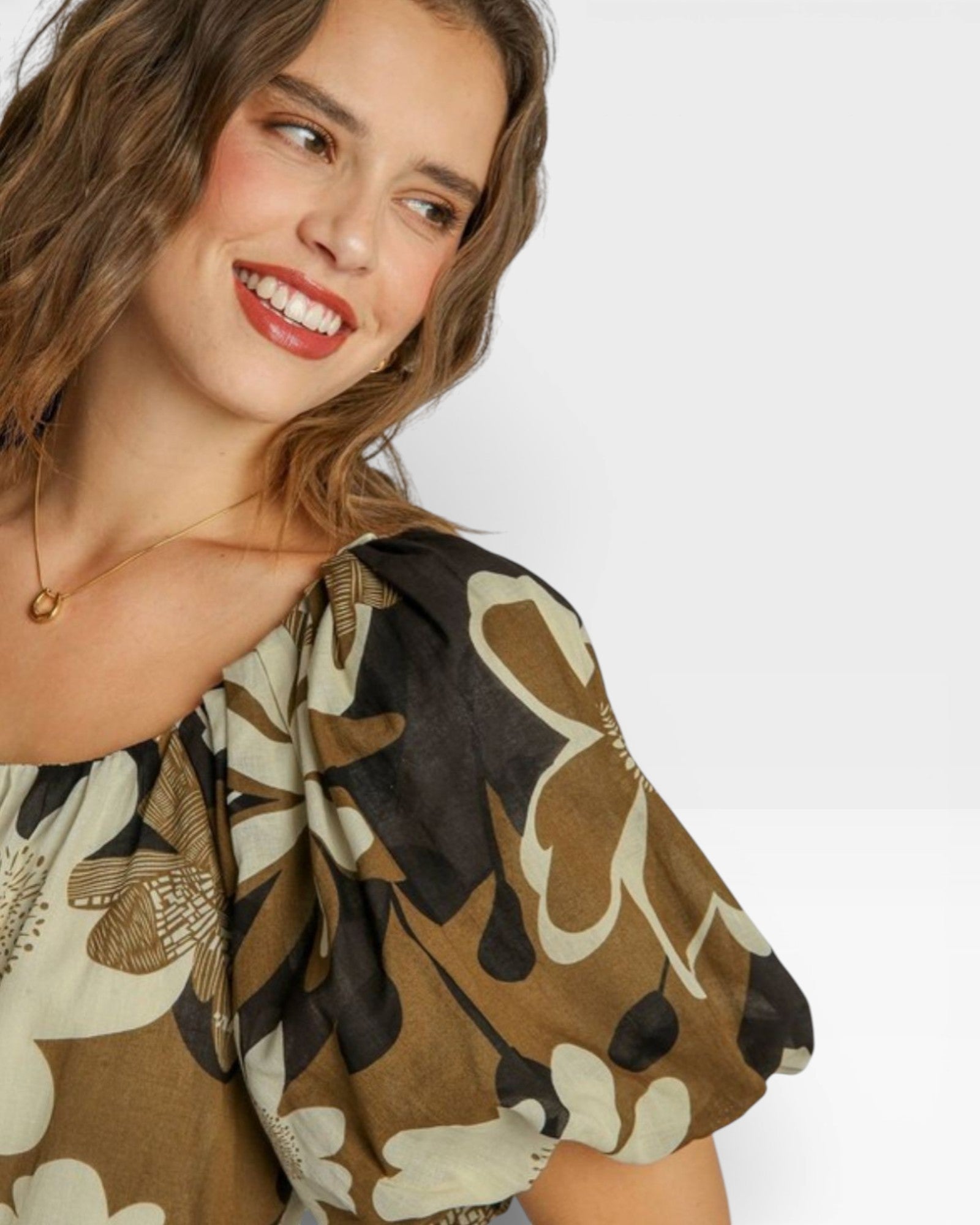 Woman wearing a patterned top with a neutral background