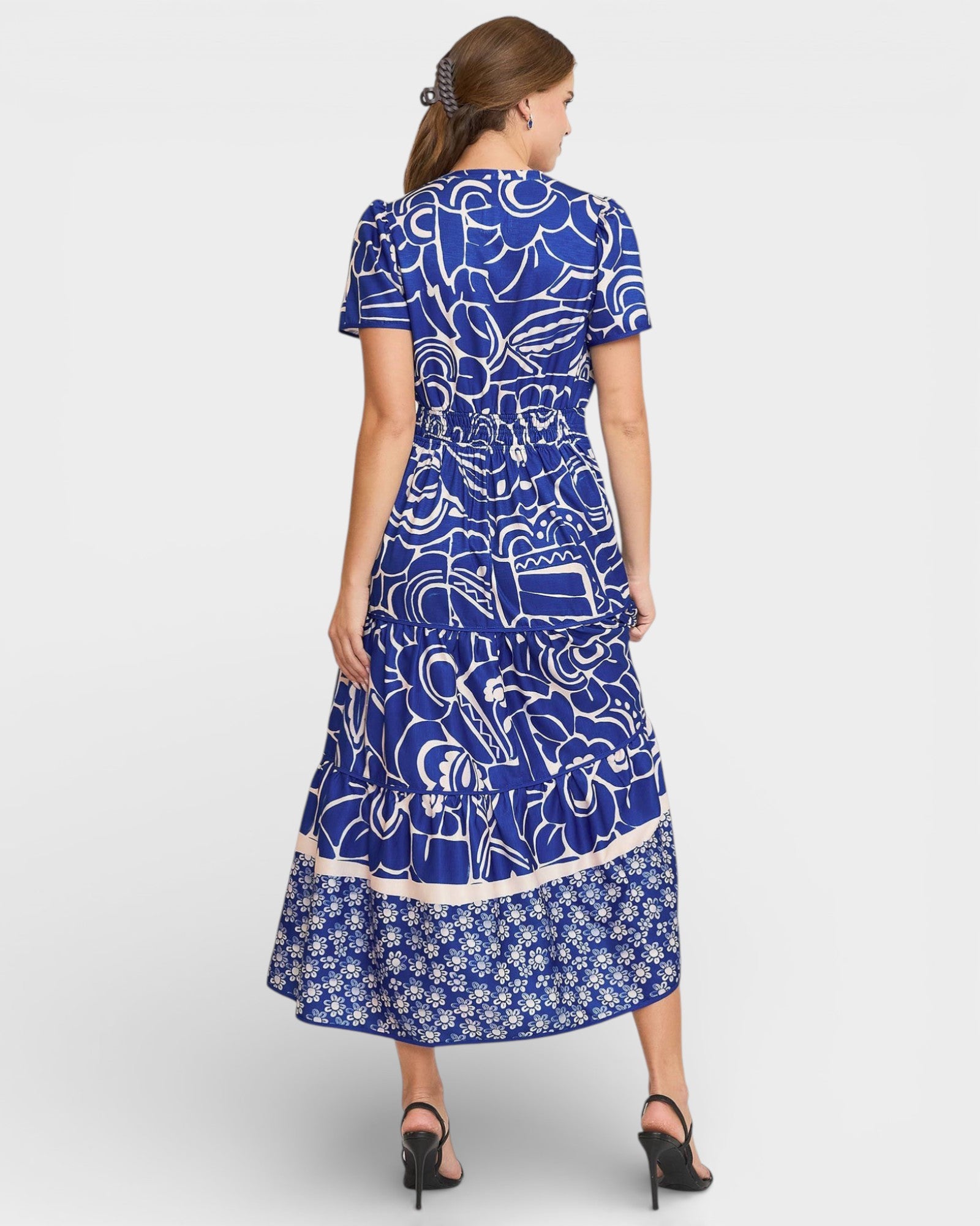 Woman wearing a blue patterned dress on a white background