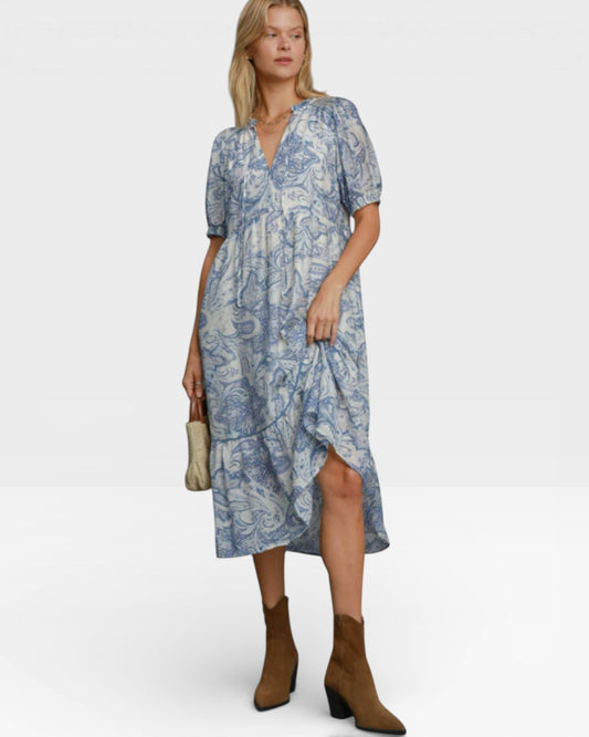 Woman wearing a blue patterned dress on a white background