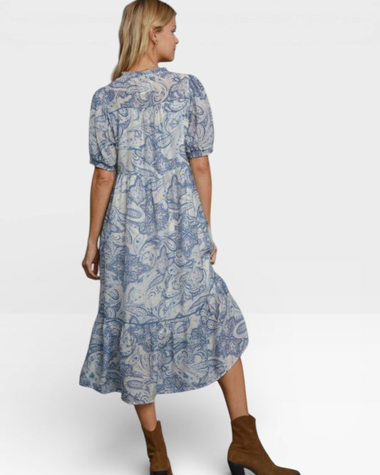 Woman wearing a blue patterned dress on a white background