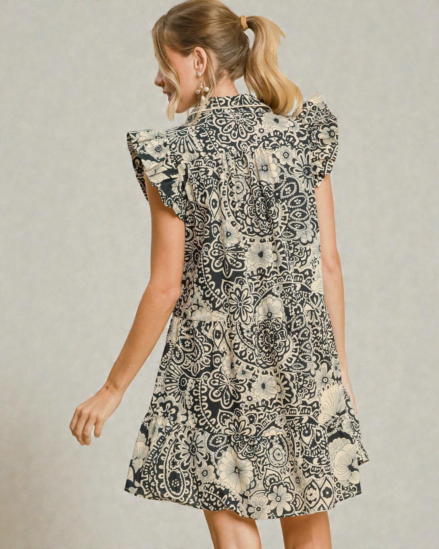 Woman wearing a black and white patterned dress on a plain background