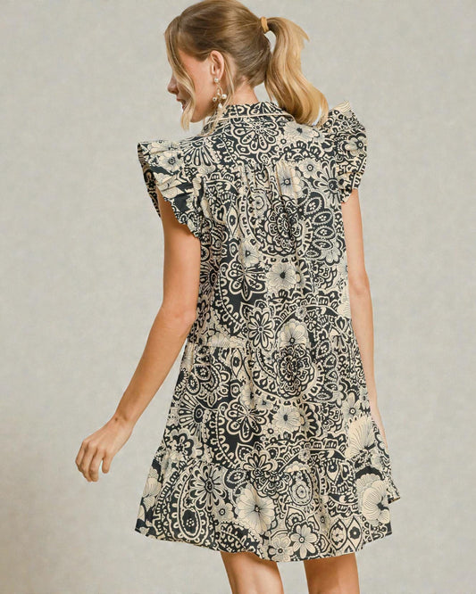 Woman wearing a black and white patterned dress on a plain background