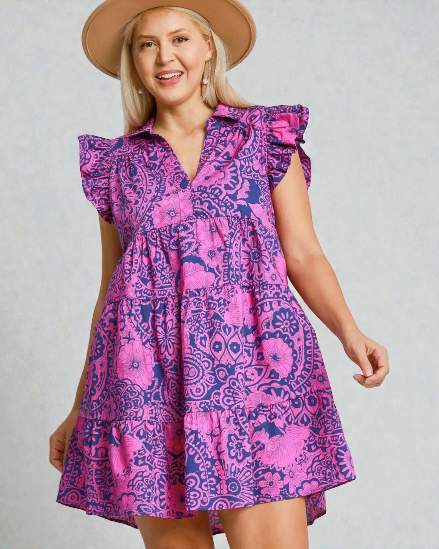 Woman wearing a pink and purple patterned dress with a plain background