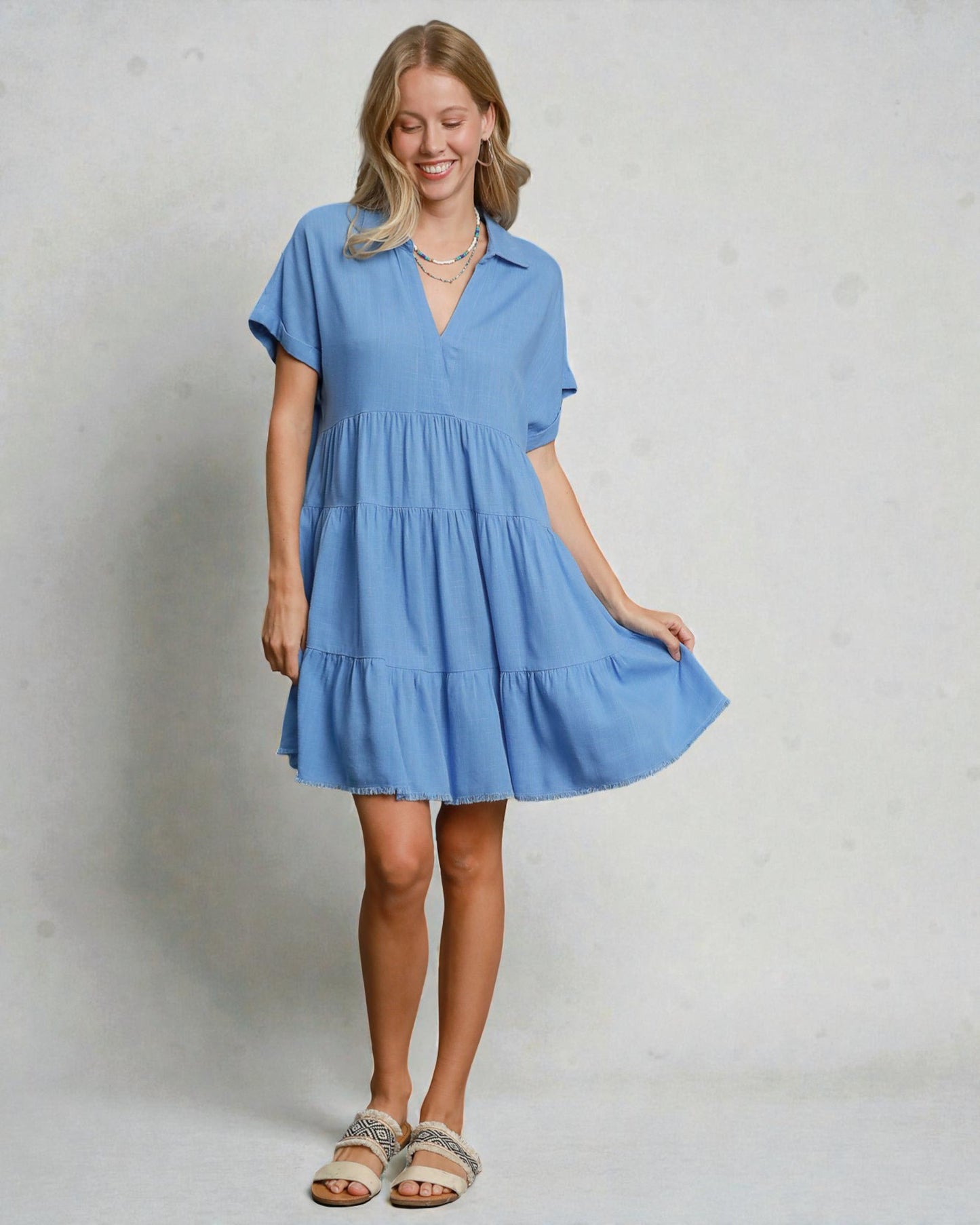 Woman wearing a blue dress against a plain background