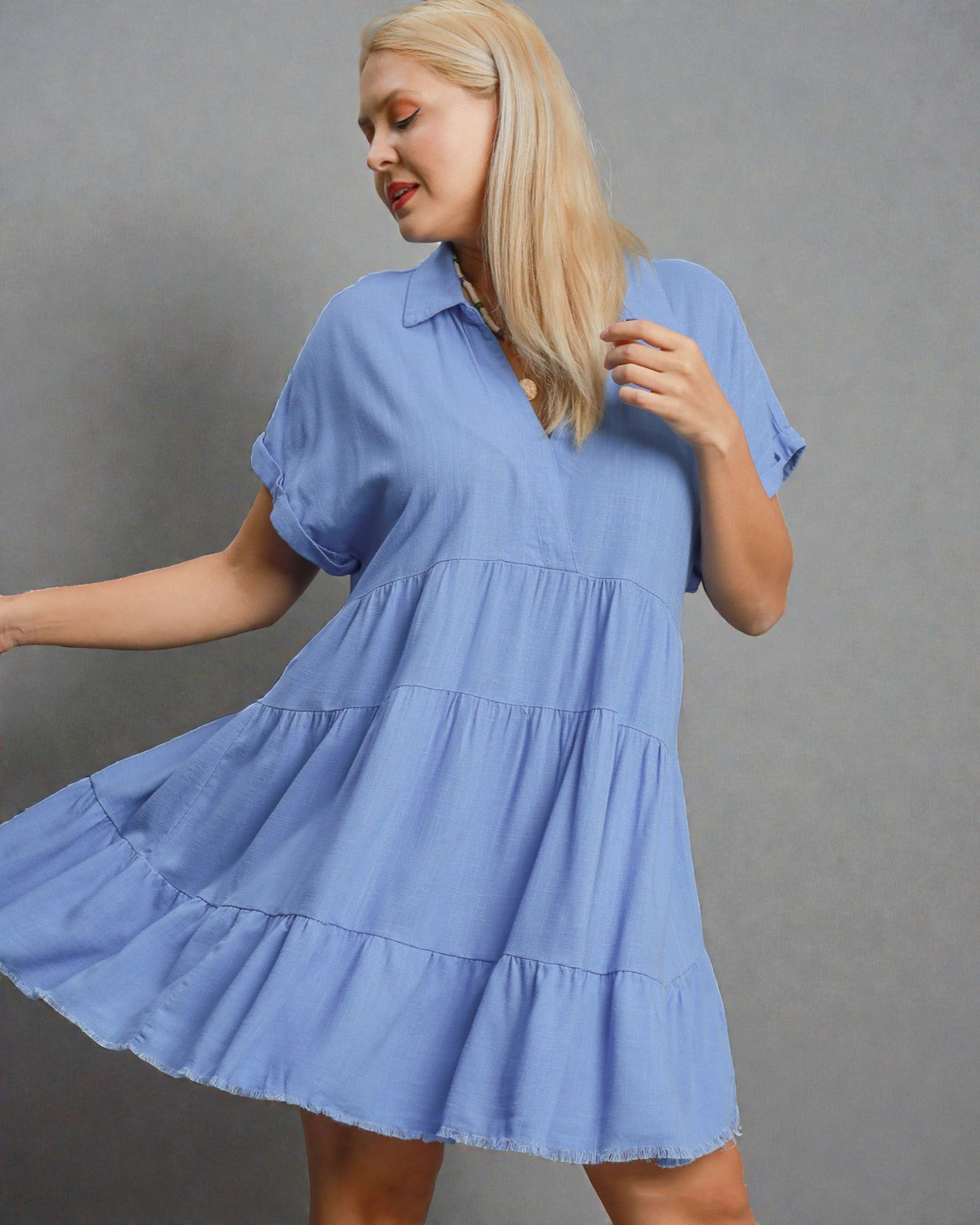 Woman wearing a blue dress against a gray background