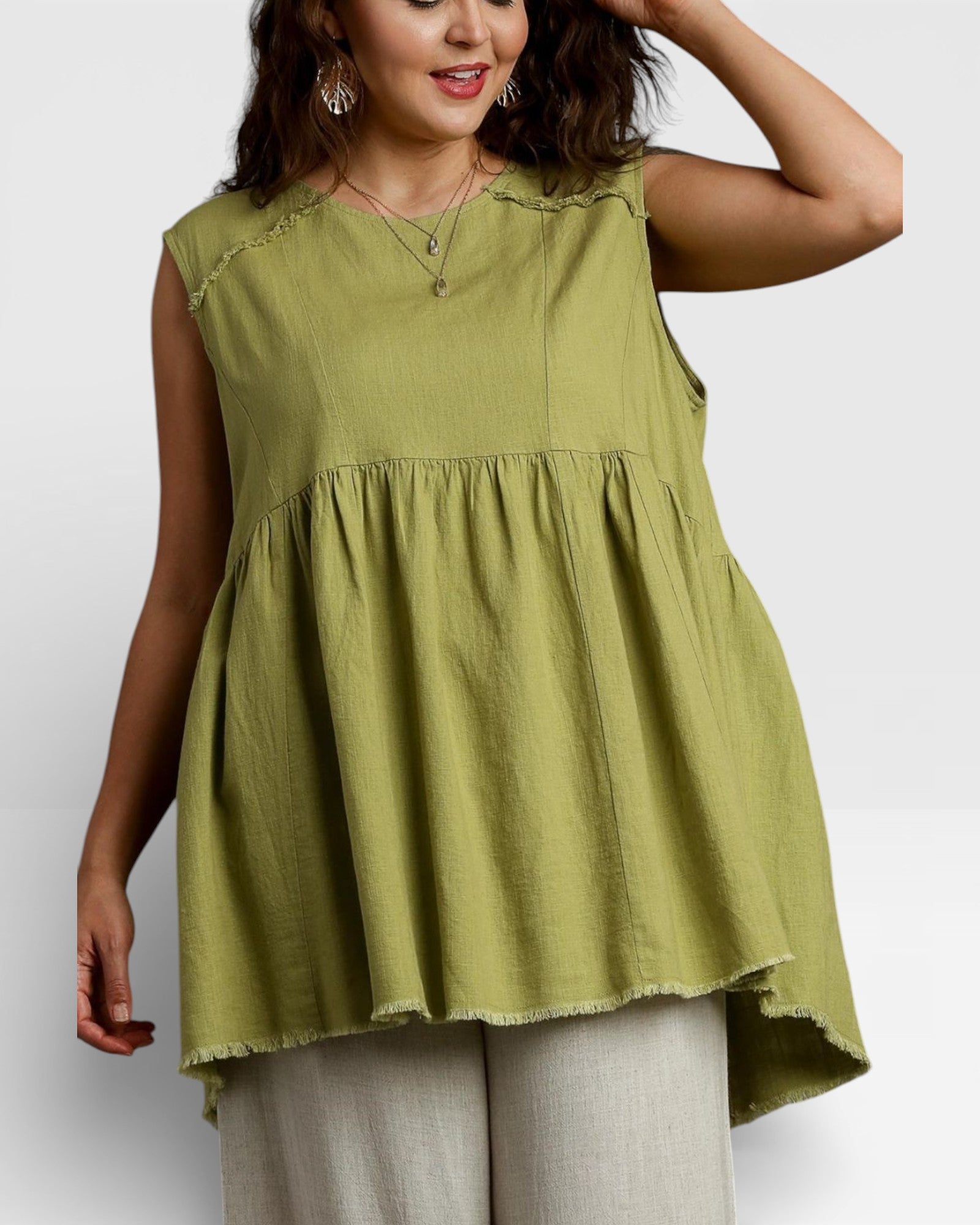 Woman wearing a green sleeveless top on a white background