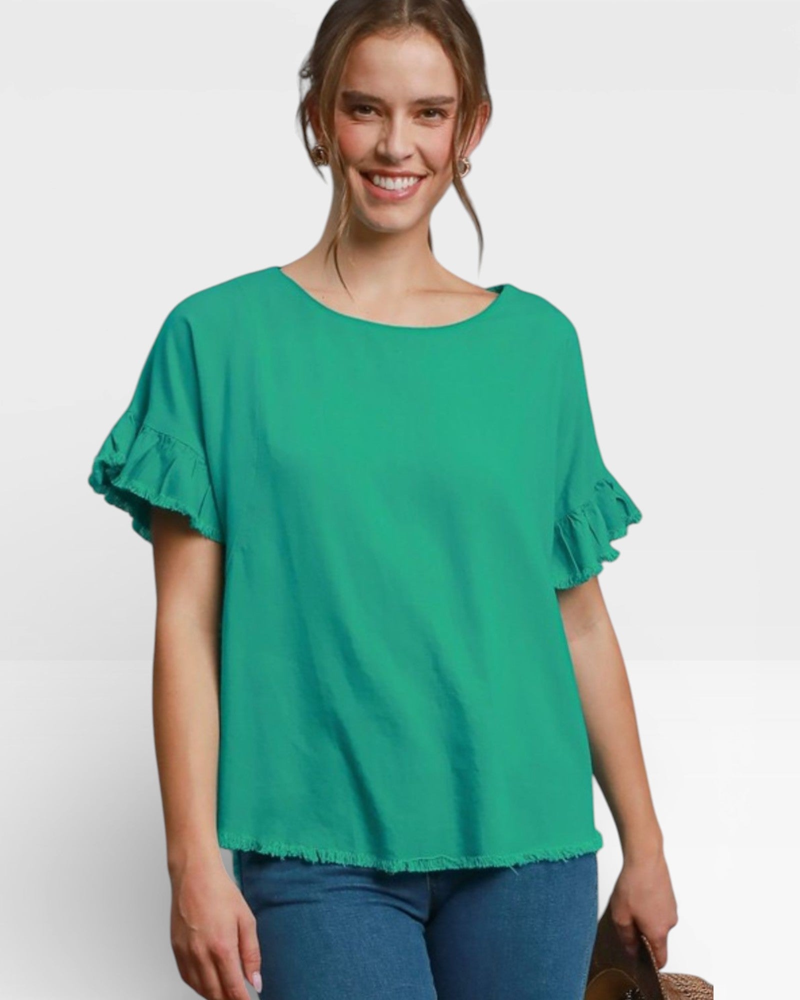 Woman wearing a green blouse with ruffled sleeves on a white background