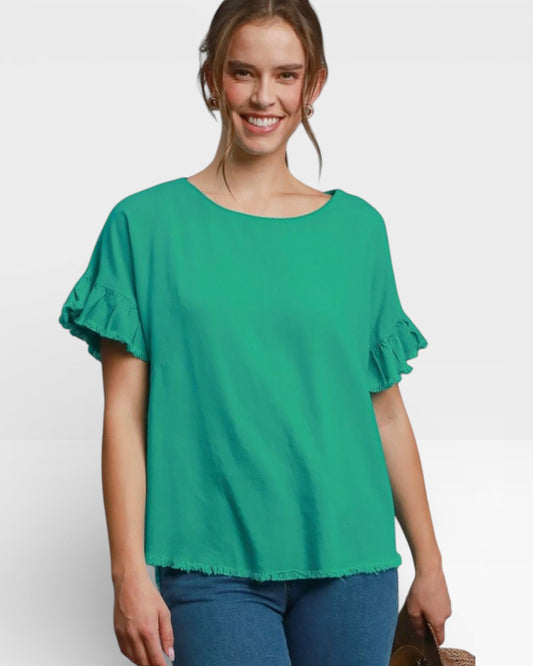 Woman wearing a green blouse with ruffled sleeves on a white background