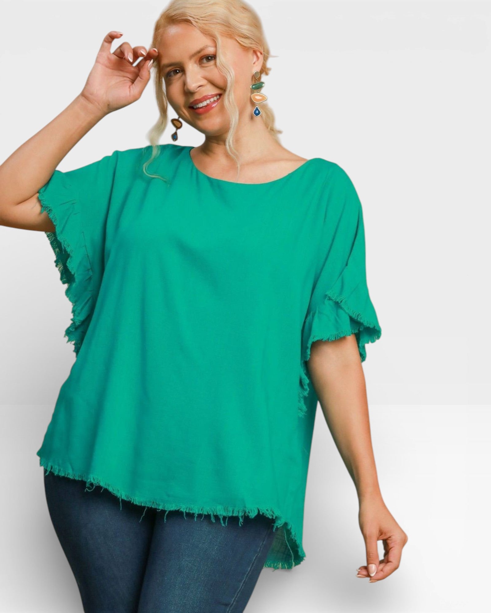 Woman wearing a green blouse with ruffled sleeves on a white background