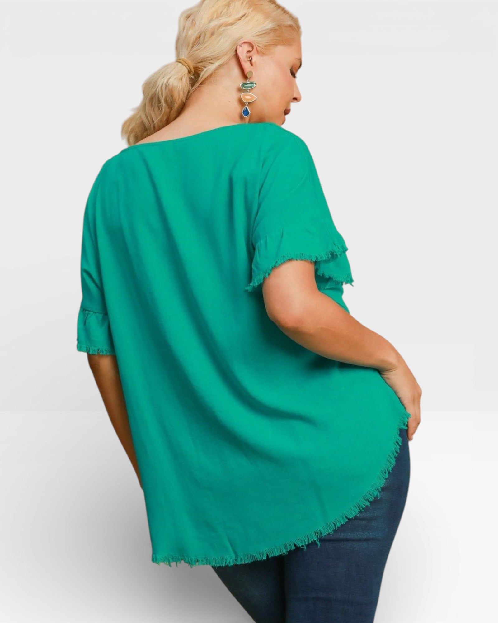 Woman wearing a green blouse with rolled-up sleeves on a white background