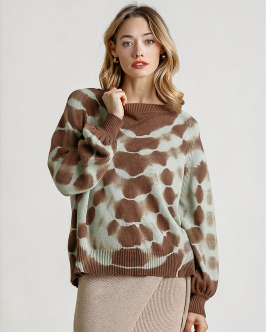 Woman wearing a brown and beige patterned sweater on a plain background