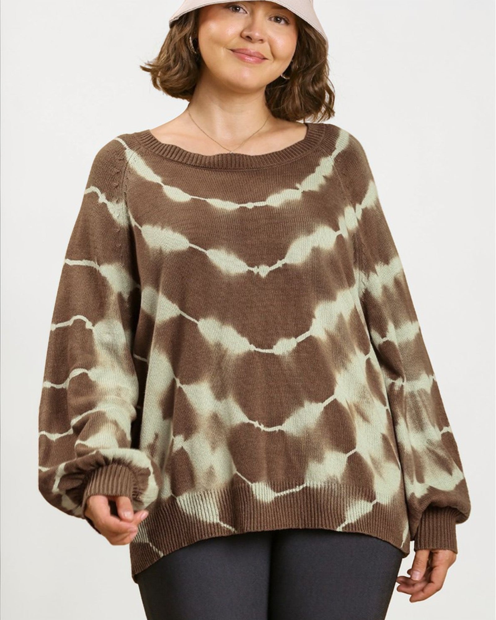 Person wearing a brown and beige tie-dye sweater on a white background