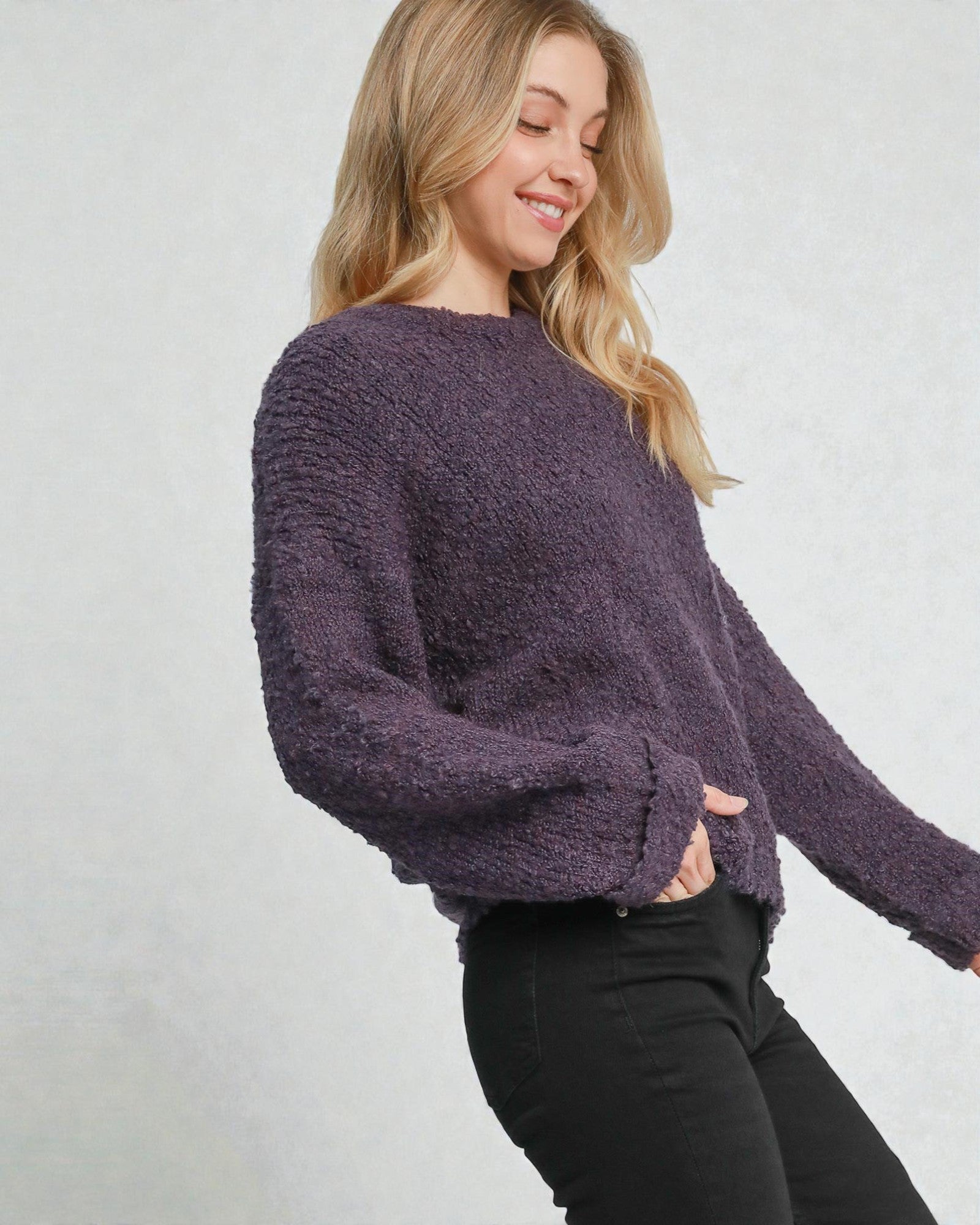 Woman wearing a purple sweater against a plain background