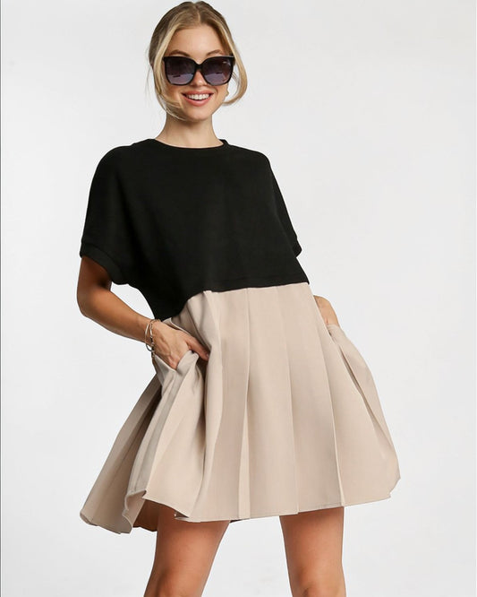 Woman wearing a black top and beige skirt on a white background