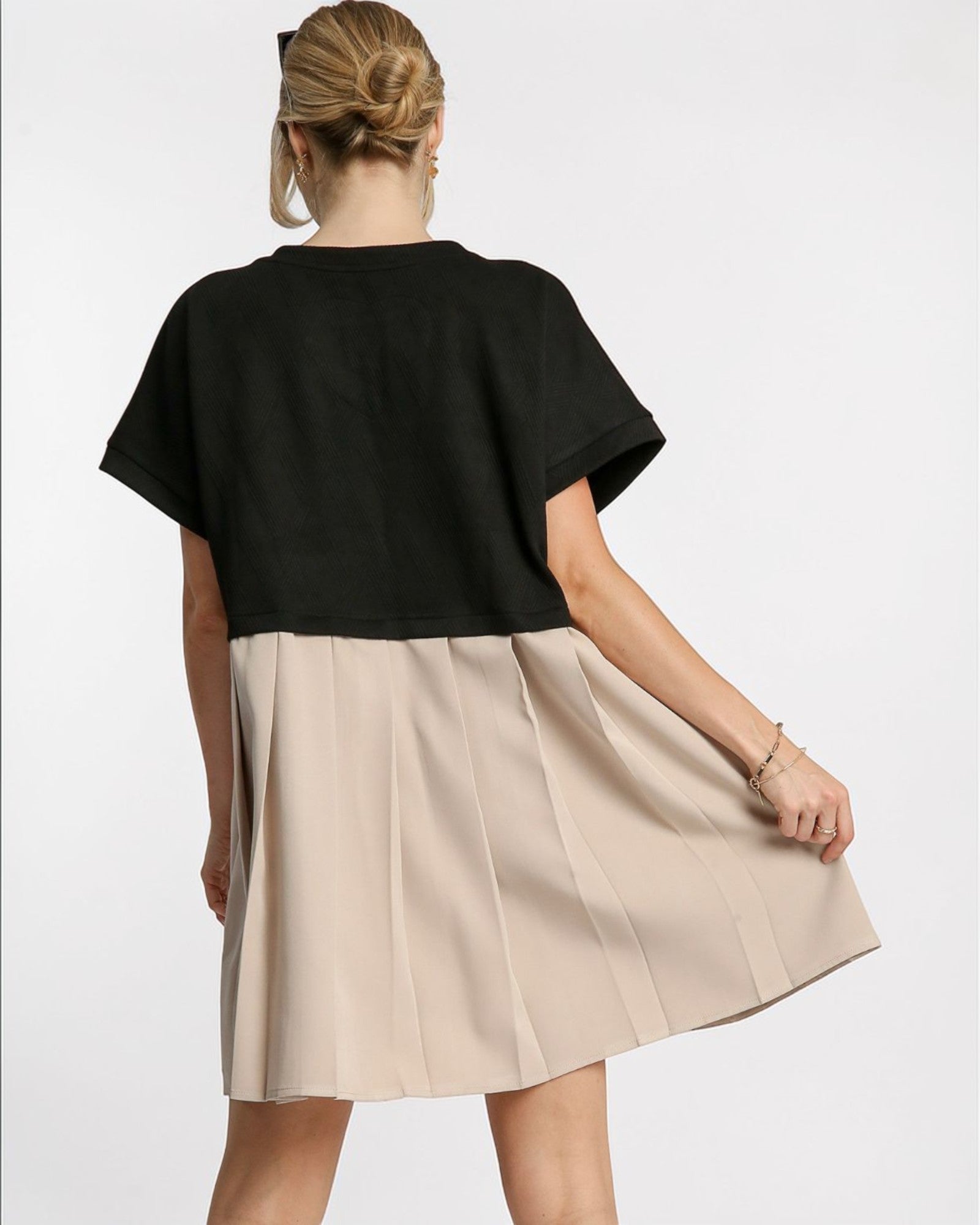 Woman wearing a black top and beige skirt on a white background