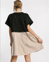 Woman wearing a black top and beige skirt on a white background