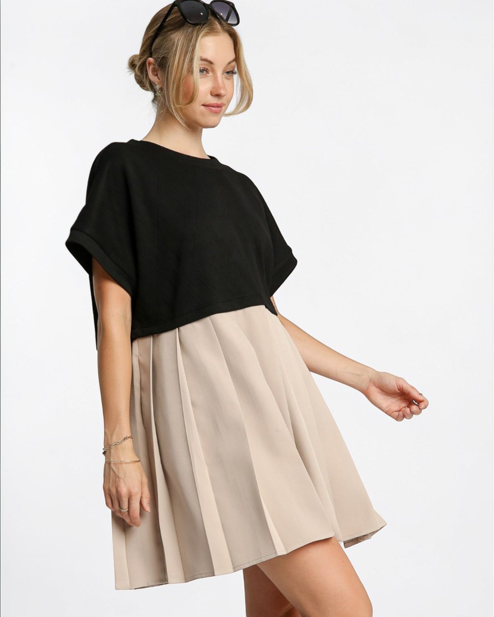 Woman wearing a black top and beige skirt on a white background