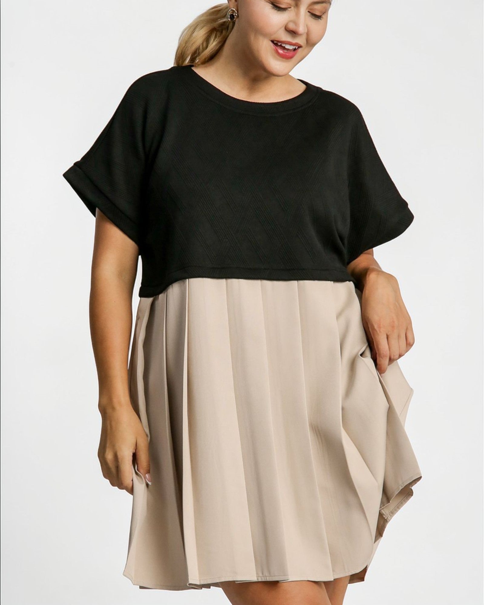 Woman wearing a black top and beige skirt on a white background