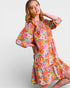 Woman wearing a colorful floral dress on a white background