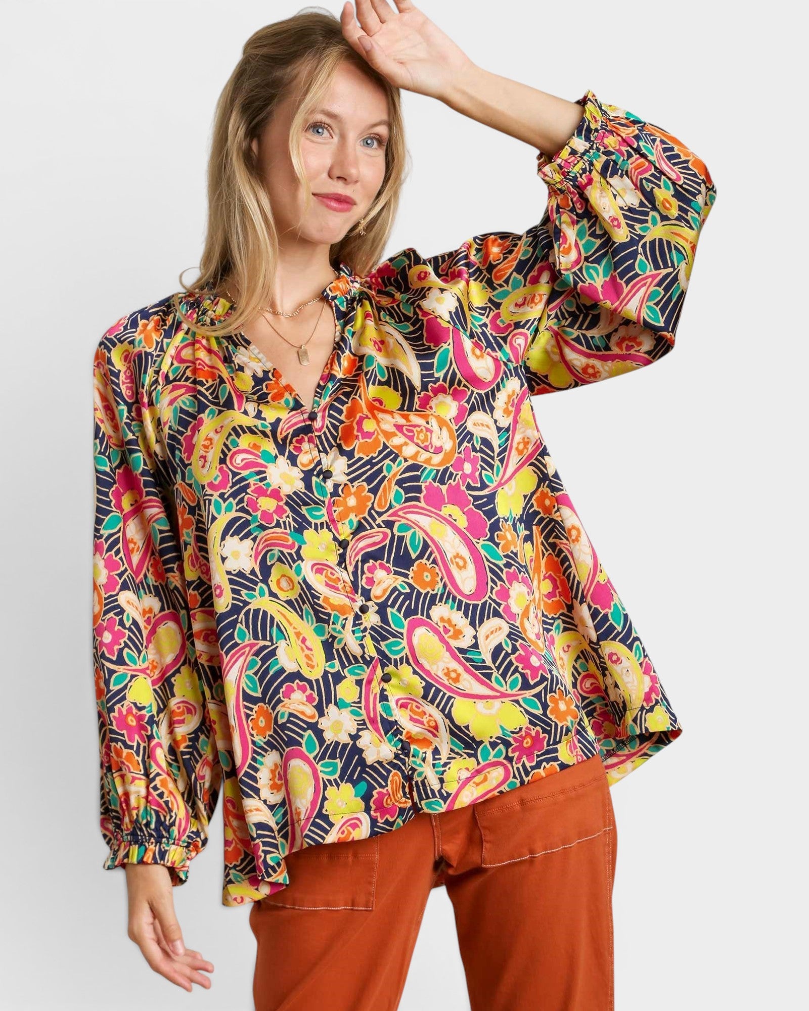 Woman wearing a colorful patterned blouse against a white background