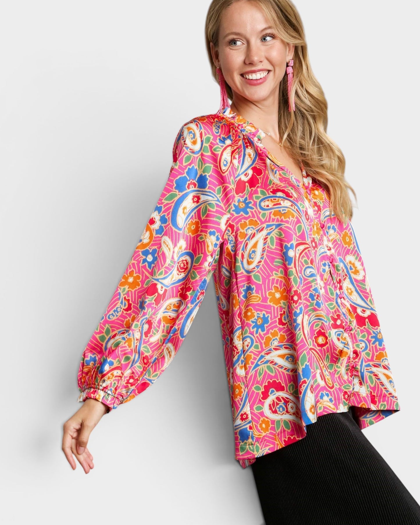 Woman wearing a colorful patterned blouse against a white background