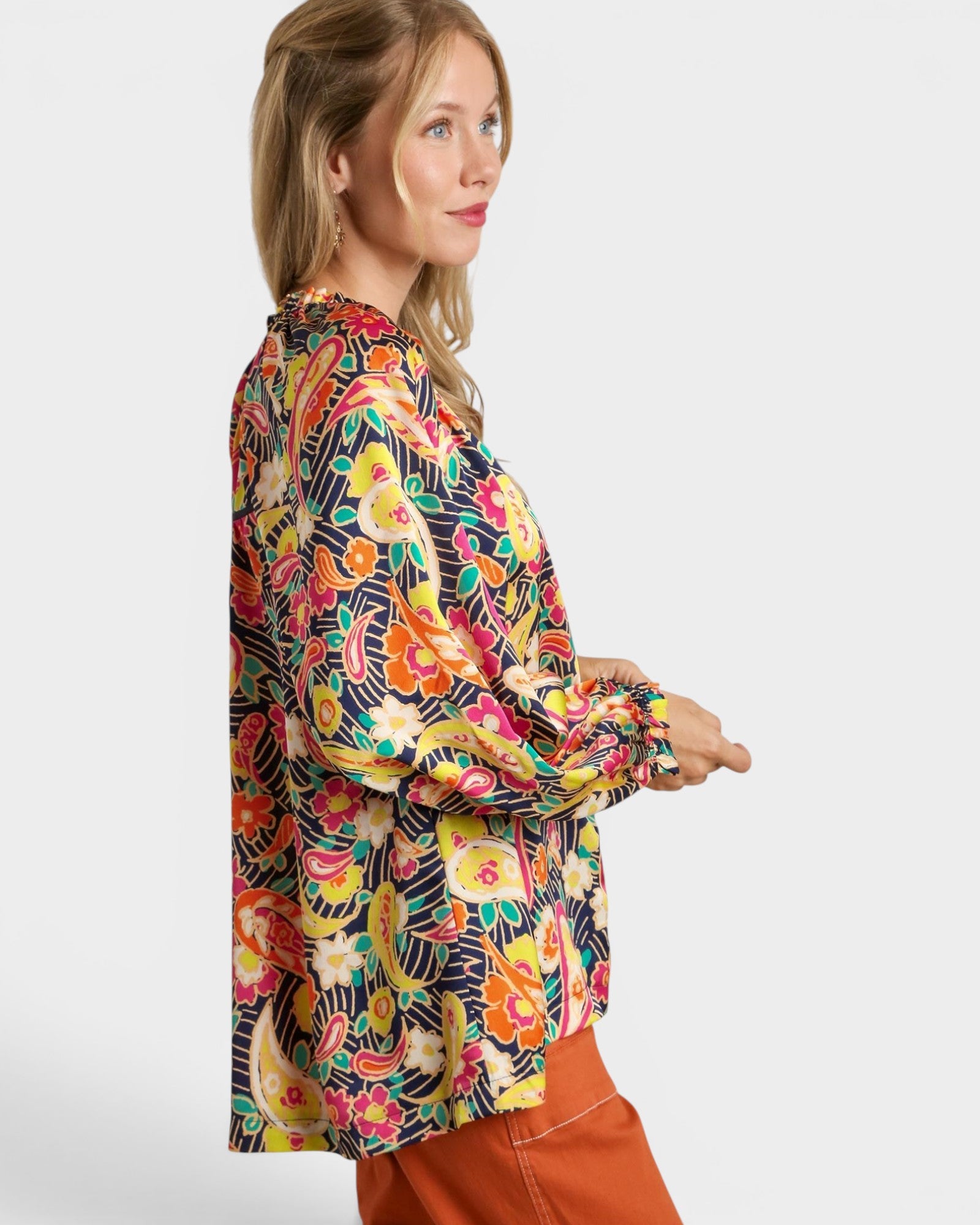 Woman wearing a colorful floral blouse on a white background