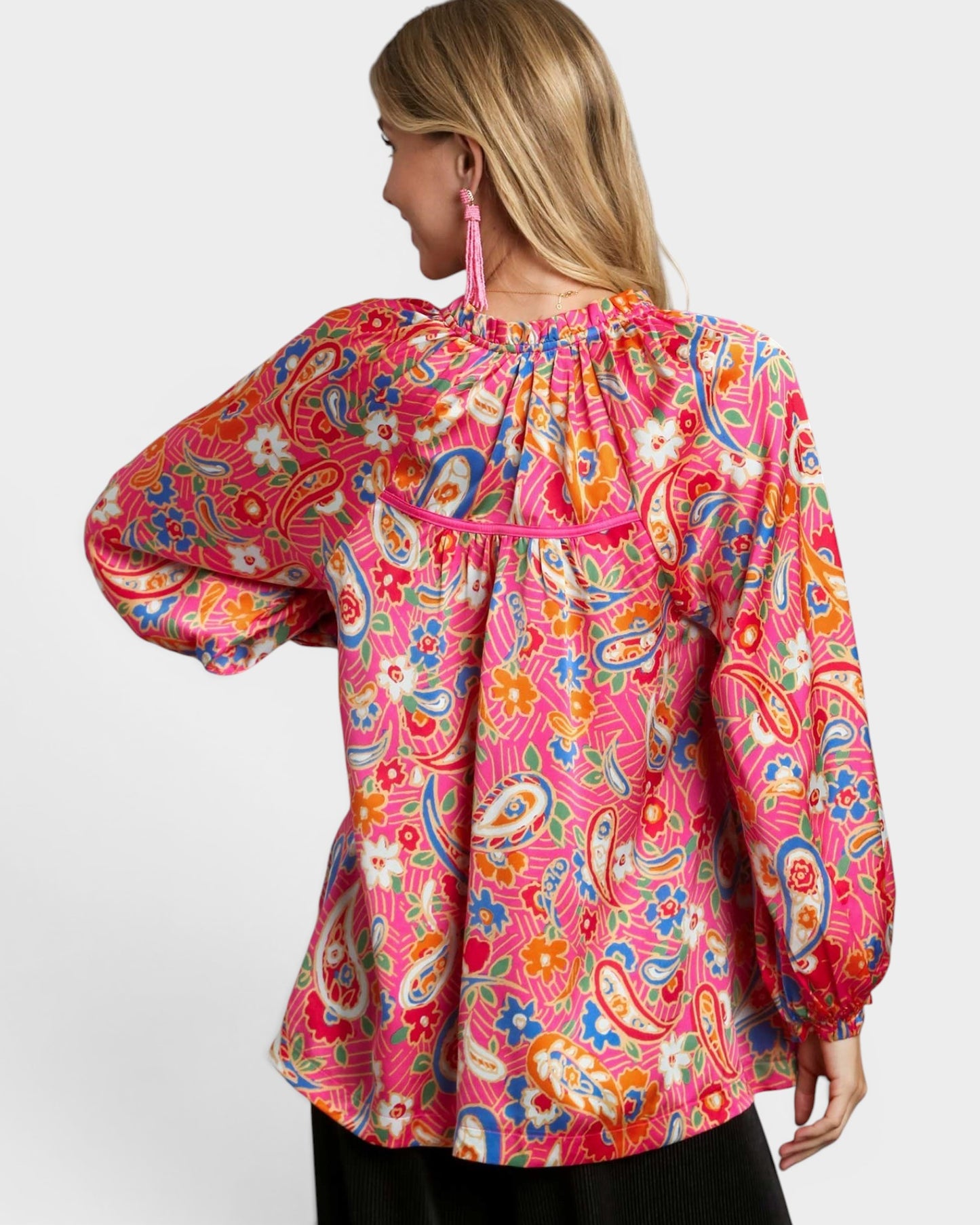 Woman wearing a colorful patterned blouse on a white background