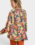 Woman wearing a colorful patterned shirt on a white background