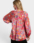 Woman wearing a colorful patterned blouse on a white background