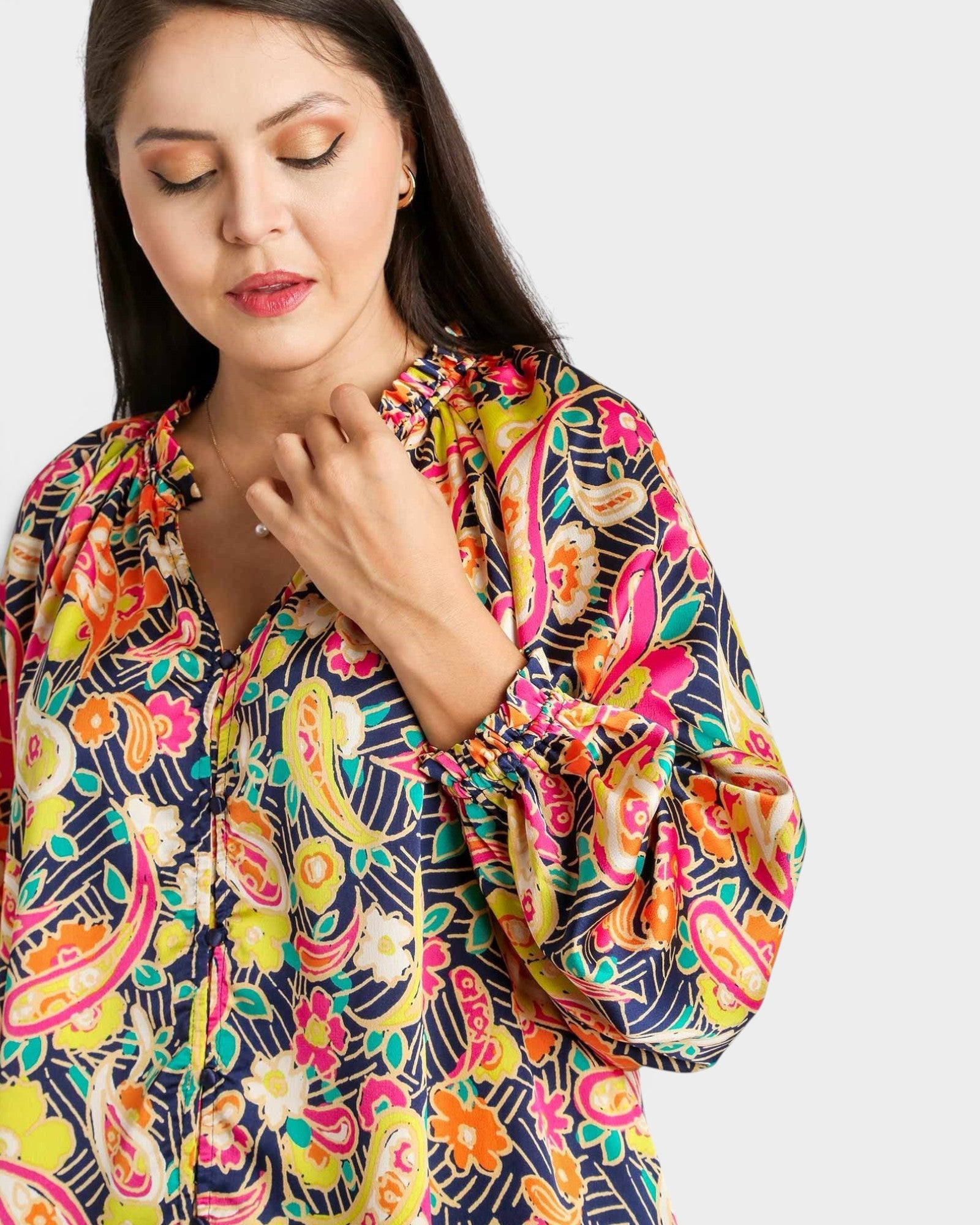 Woman wearing a colorful patterned shirt on a white background