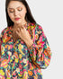Woman wearing a colorful patterned shirt on a white background