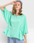 Woman wearing a light green blouse with a plain background