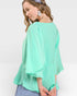 Woman wearing a light green blouse with a white background