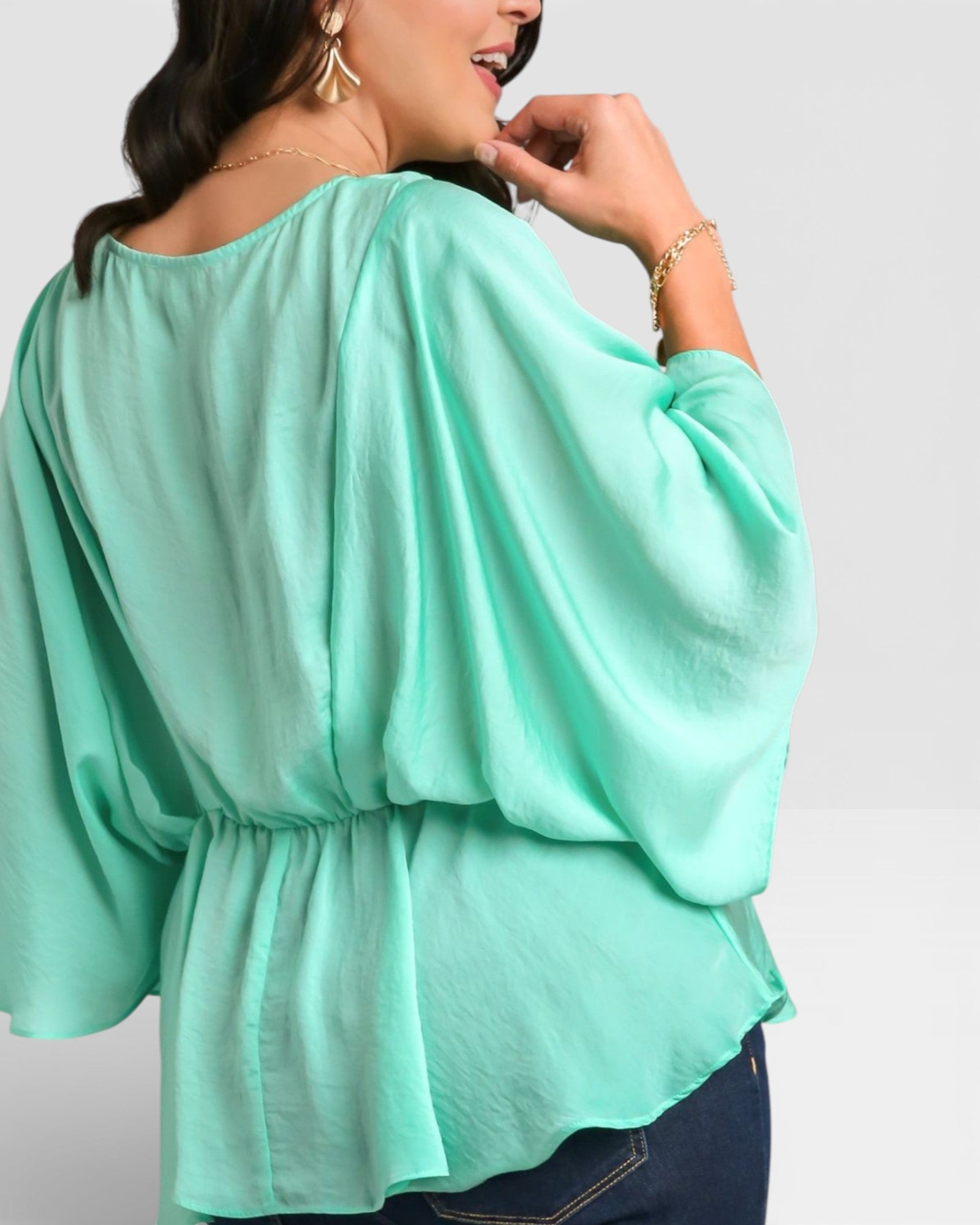 Mint green blouse worn by a person on a plain background