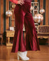 Red velvet pants worn by a person in an indoor setting with decorative elements.