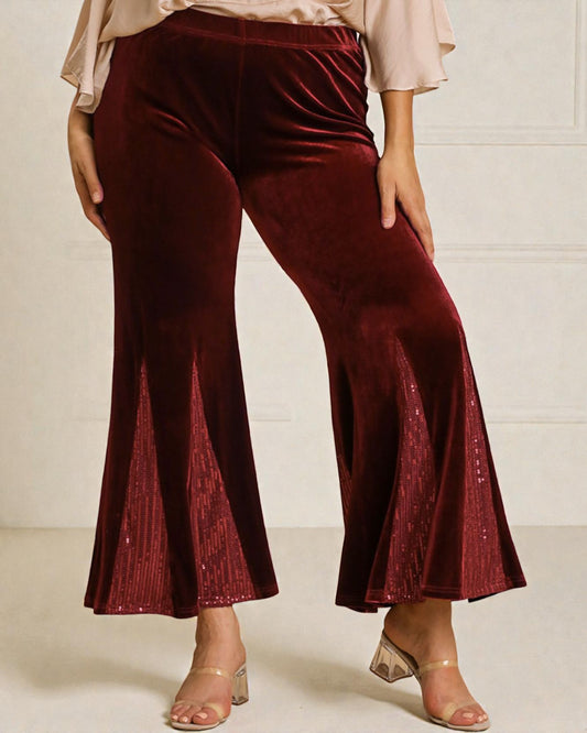 Maroon velvet pants worn by a person on a white background