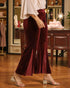 Person wearing burgundy velvet pants in a store setting