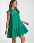 Woman wearing a green dress with smocked bodice on a white background