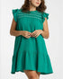 Woman wearing a green dress with ruffled sleeves on a white background
