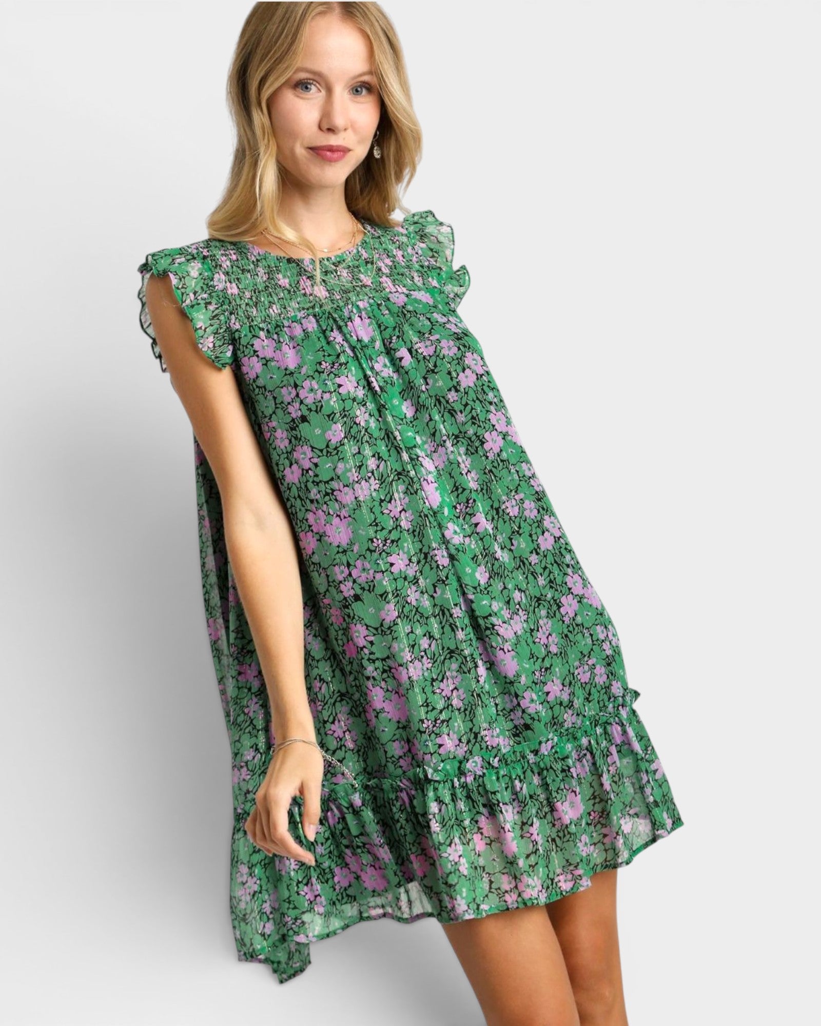 Woman wearing a green floral dress on a white background