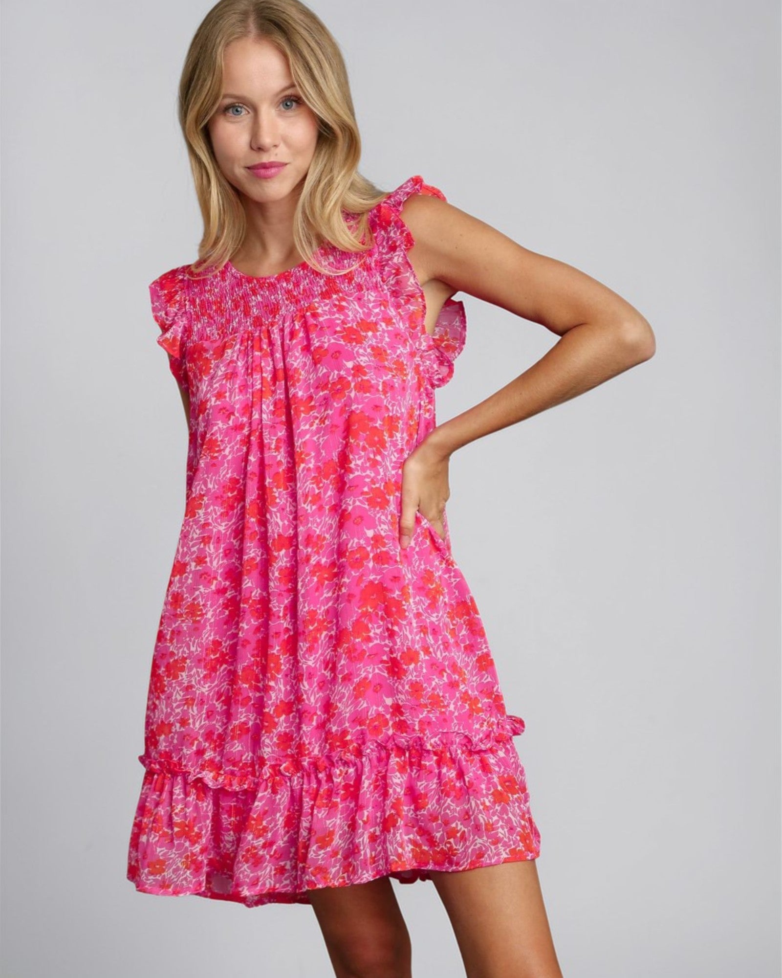 Woman wearing a pink floral dress on a gray background