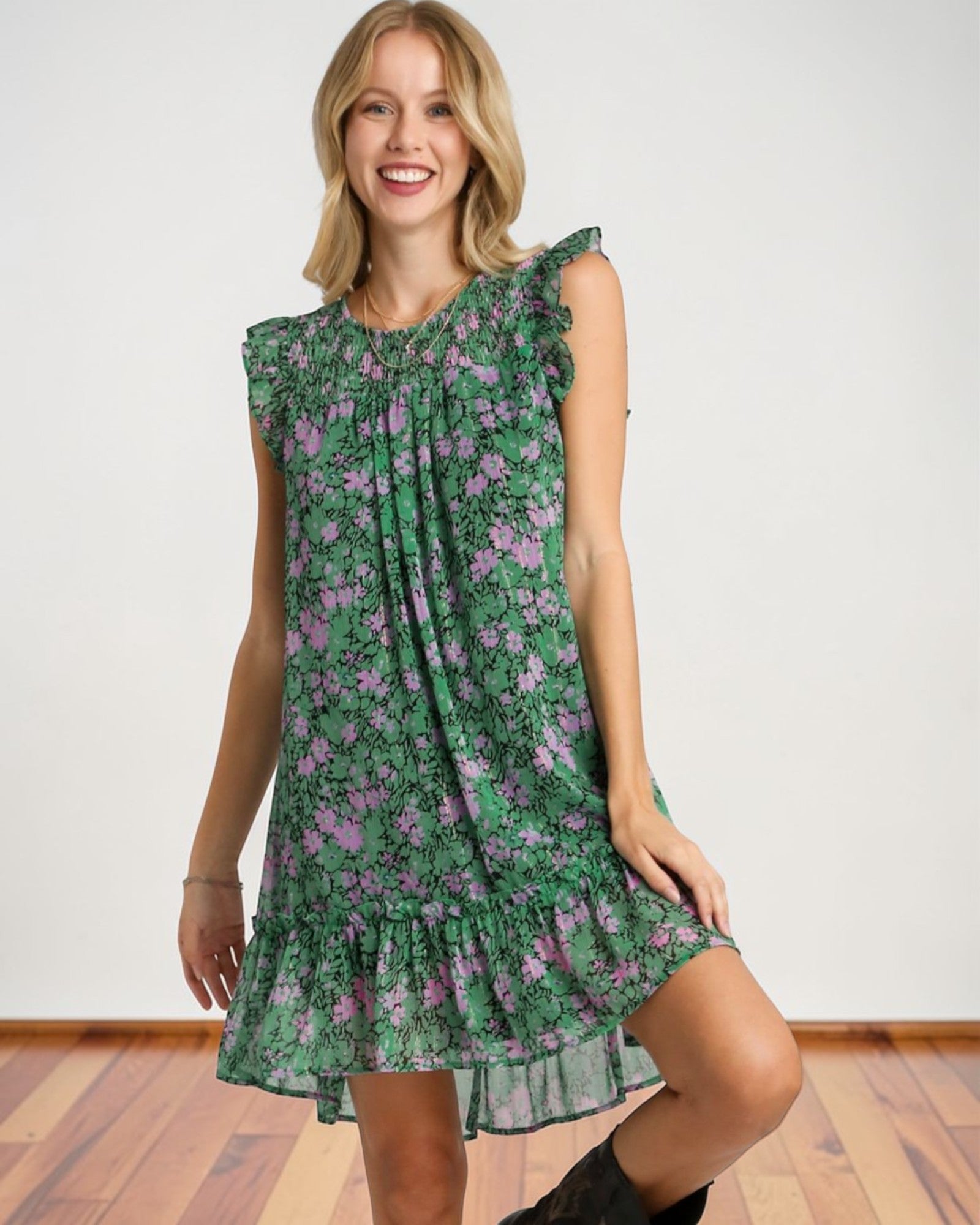Woman wearing a green floral dress against a white background