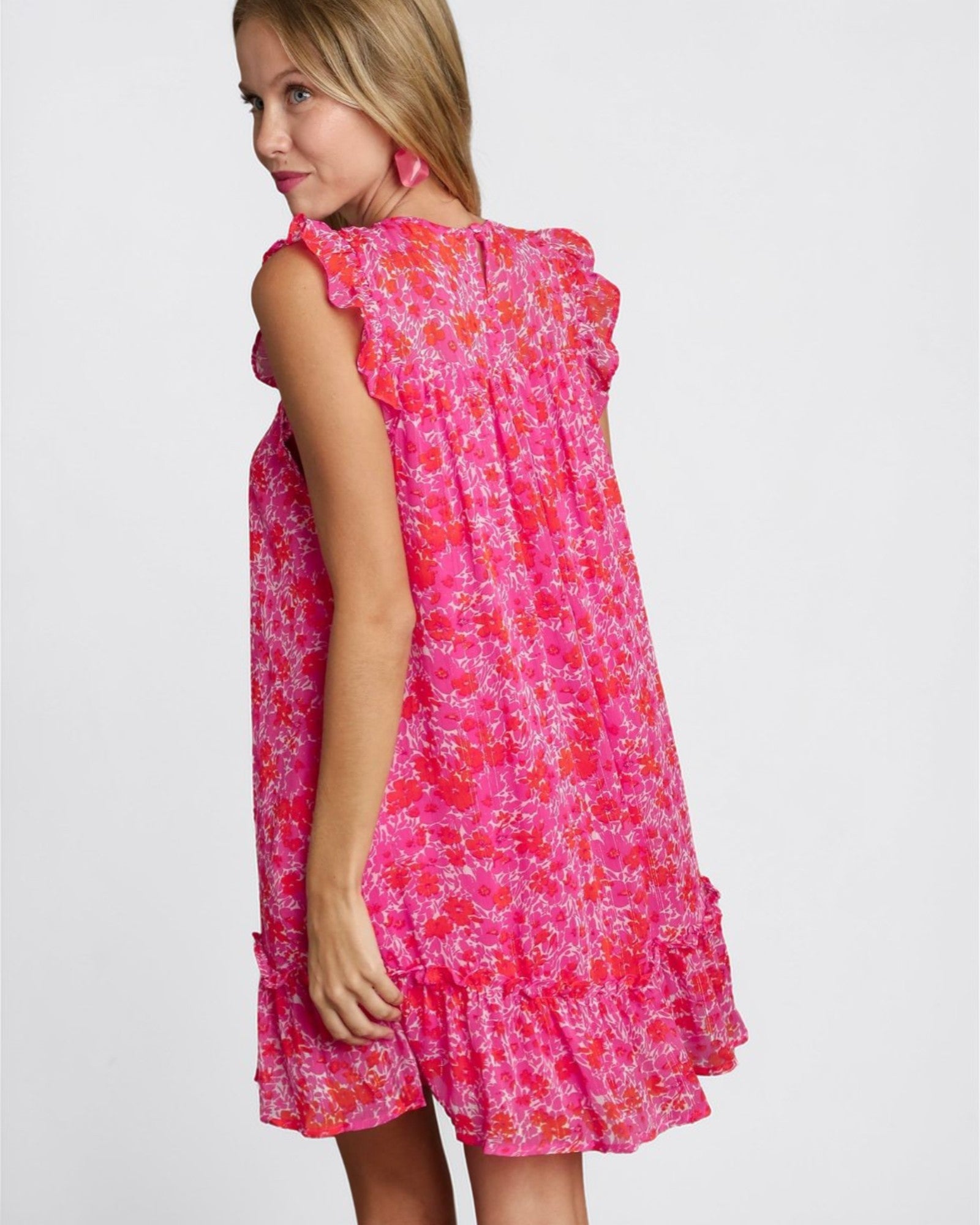 Young girl wearing a pink floral dress on a white background