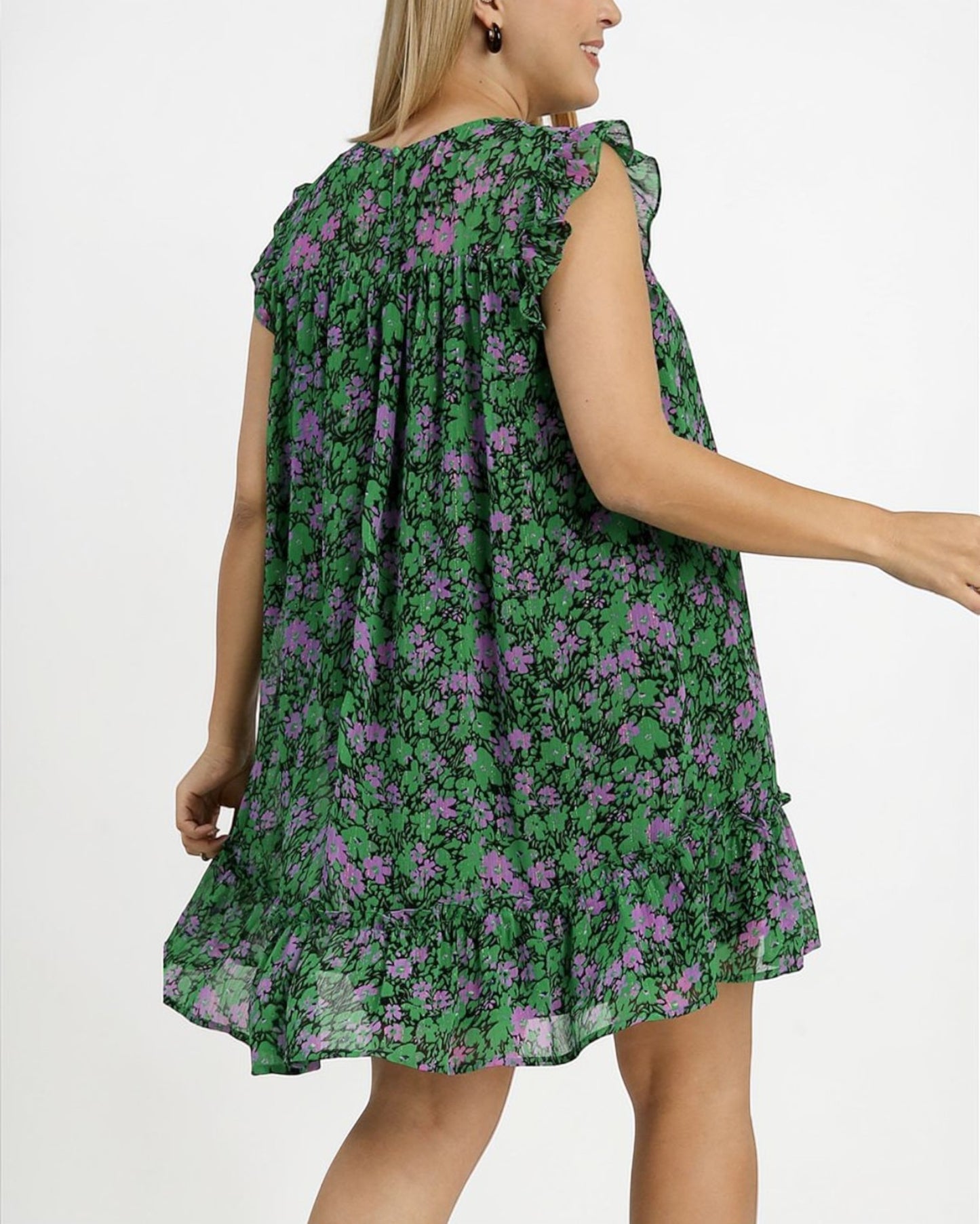 Woman wearing a green floral dress on a white background