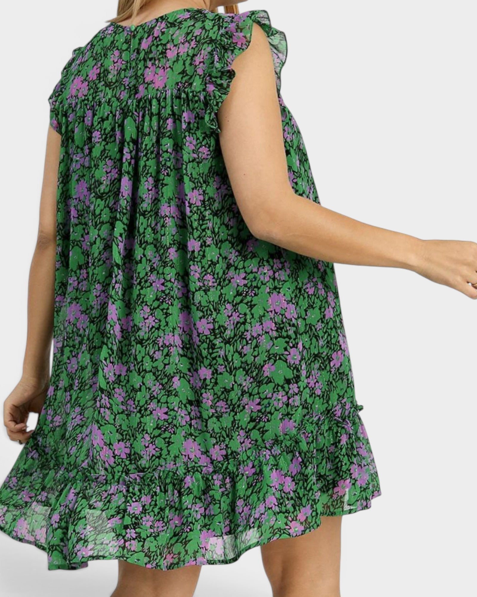Green floral dress worn by a person on a plain background