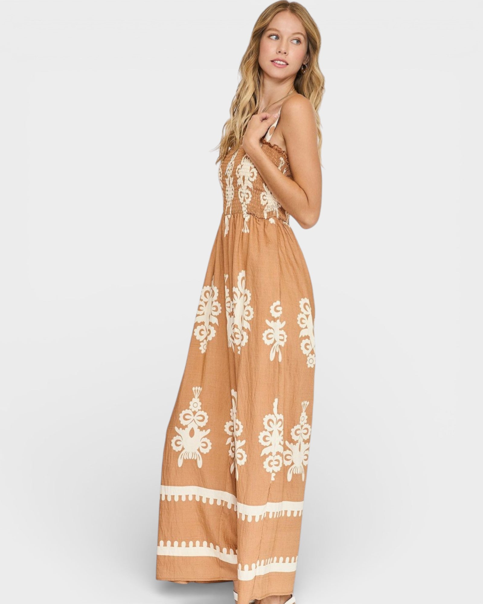 Woman wearing a long, patterned dress on a white background