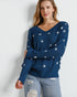 Woman wearing a blue sweater with star patterns against a white background