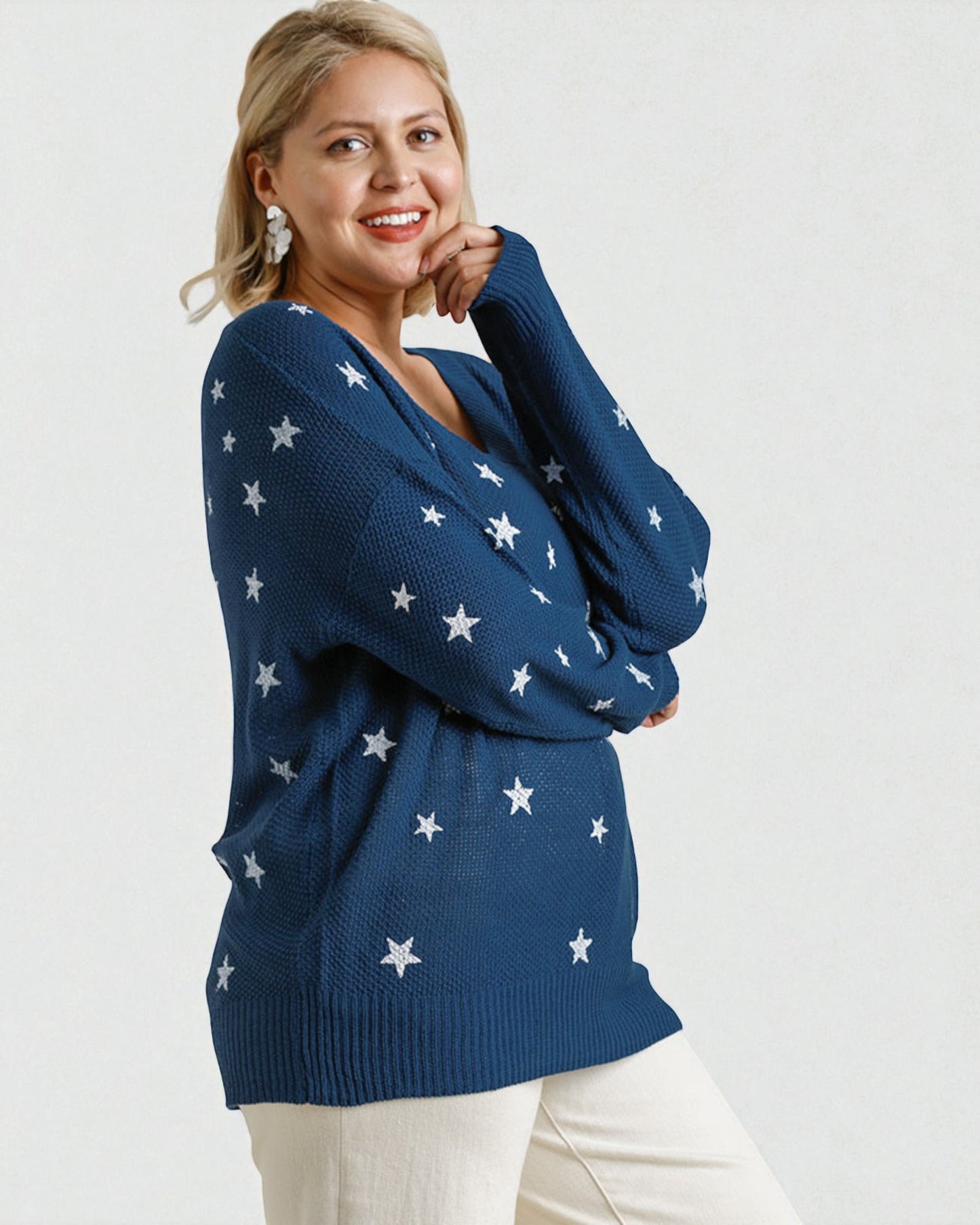 Woman wearing a blue sweater with star patterns on a white background