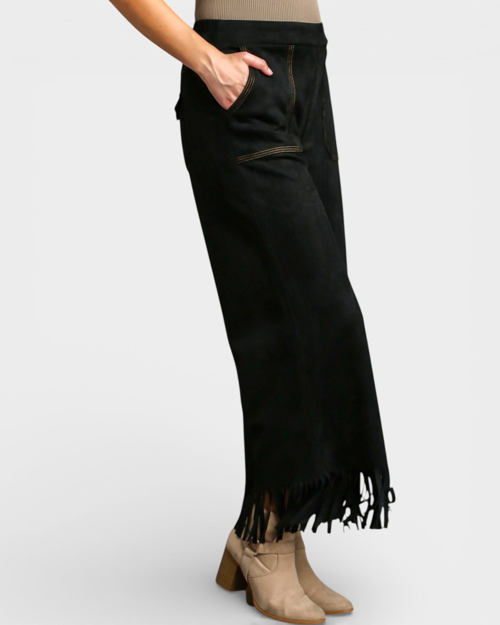 Black fringed pants worn by a person on a white background