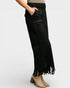 Black fringed pants worn by a person on a white background